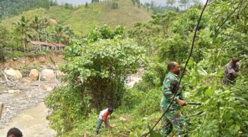 Babinsa Koramil 05/Pining Melaksanakan Gotong Royong di Lokasi Pembuatan Jembatan Gantung Perintis